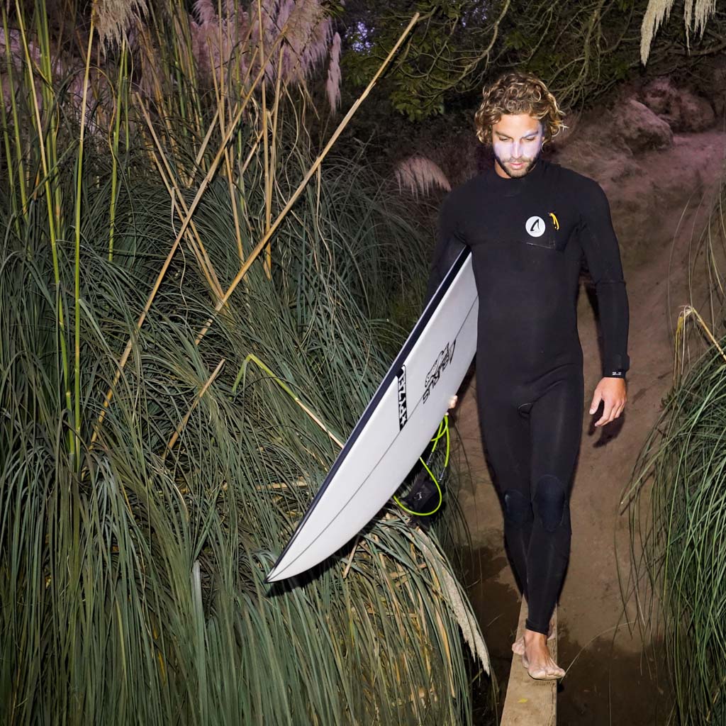 Joe Coury walking with a surfboard