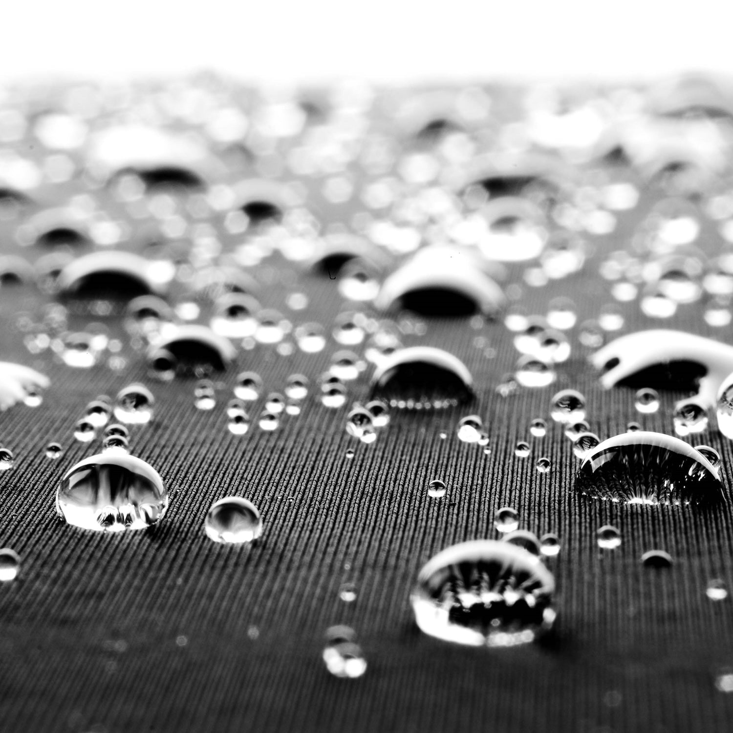 Close-up of water droplets on a textured surface of a wetsuit